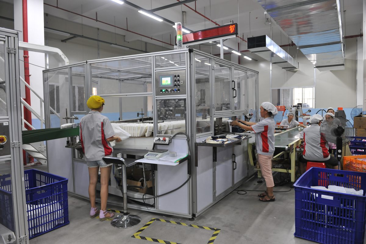 Experienced operator supervising high-speed adult diaper production