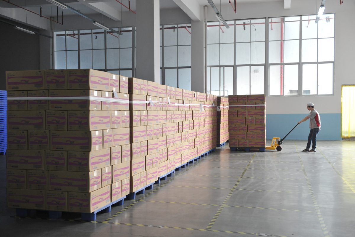 Finished OEM adult diapers palletized in warehouse — ready for FOB export shipment to 88+ countries